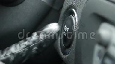 一名女司机按下汽车发动机启停按钮的宏观镜头。